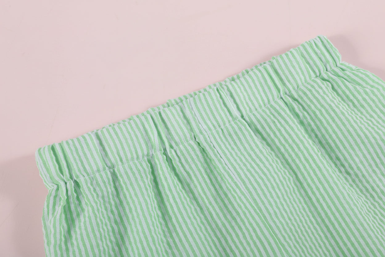 Green and white striped fabric on a light pink background