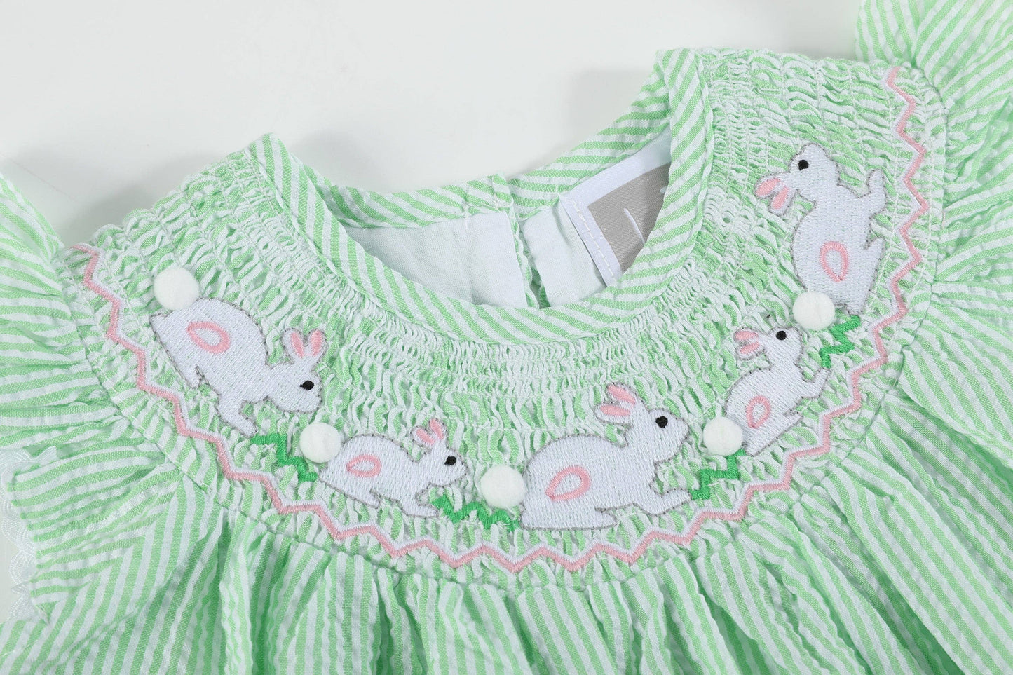 Green and white striped dress with embroidered bunnies on a white background