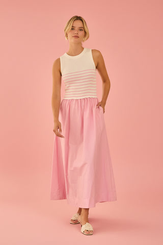 Woman wearing a white and pink sweater dress on a pink background