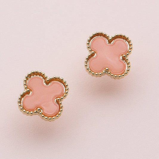 Pair of pink flower-shaped earrings on a light pink background