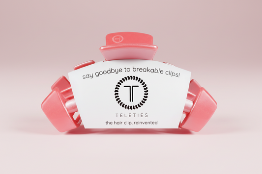 Pink hair clip with Teleties branding on a pink background
