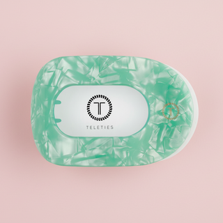 Green marbled hair clip on a pink background