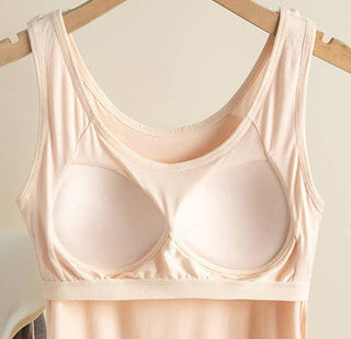 Beige tank top with a built-in bra on a wooden hanger against a light background