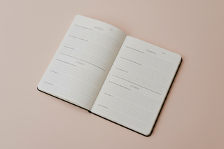 Open notebook with lined pages on a beige background
