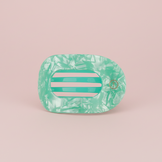 Green marbled hair clip on a pink background