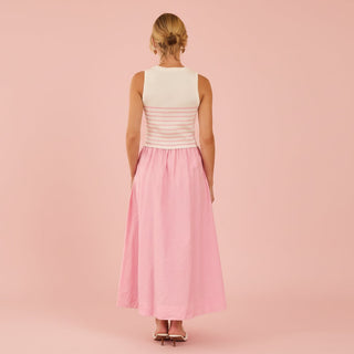 Woman wearing a white and pink sweater dress on a pink background