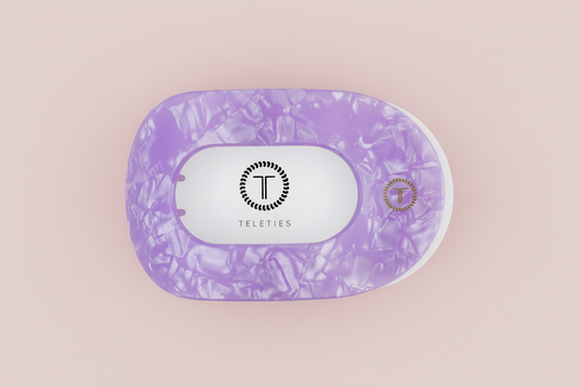 Purple marbled hair clip on a pink background