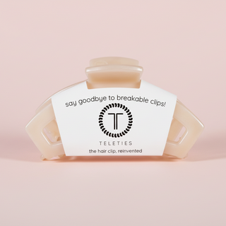 Beige hair clip on a pink background