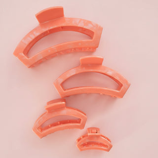 coral hair clip on a pink background