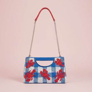Blue and red checkered bag with lobster design on a pink background