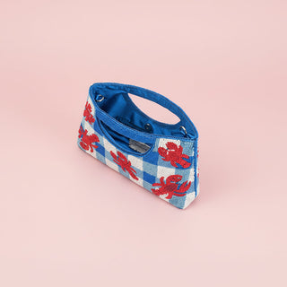 Blue and red checkered bag with lobster design on a pink background