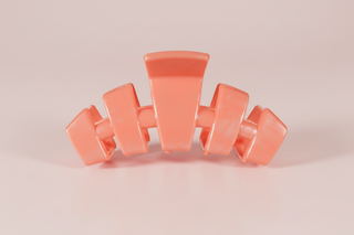coral hair clip on a pink background