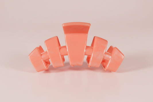 coral hair clip on a pink background