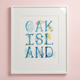Framed artwork with 'OAK ISLAND' text featuring beach-themed illustrations on a pink background.