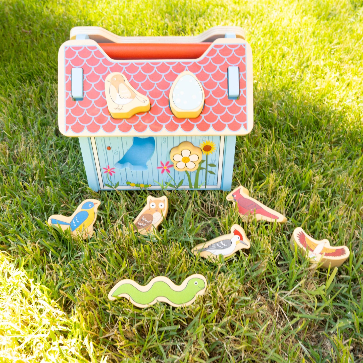 Children's toy chest with animal figures on a grassy background