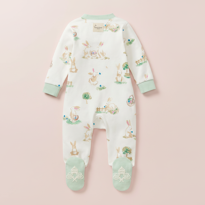 Baby onesie with Easter-themed design on a pink background