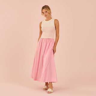 Woman wearing a white and pink sweater dress on a pink background