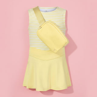 Yellow dress with a matching crossbody bag on a light pink background