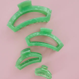 Green hair clip on a pink background