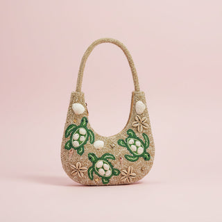 Handbag with turtle designs on a pink background