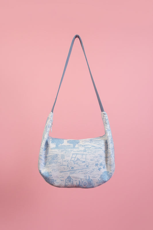 Blue shoulder bag on a pink background