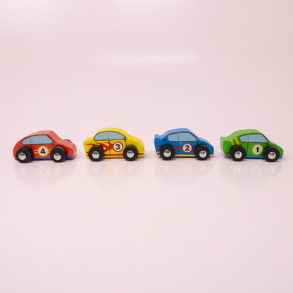 Four colorful toy cars arranged in a row on a pink background