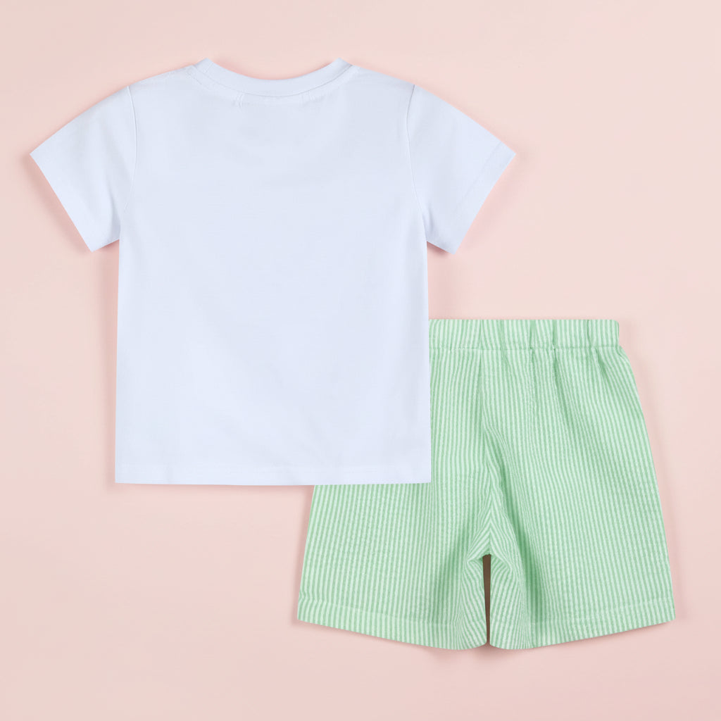 White t-shirt and green checkered shorts set on a pink background