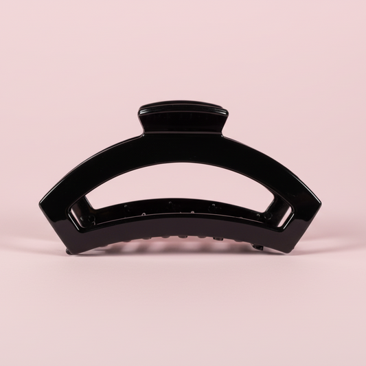 Black hair clip on a pink background