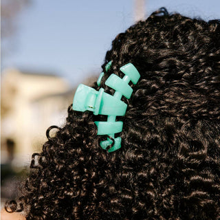 Teal claw clip in curly hair 