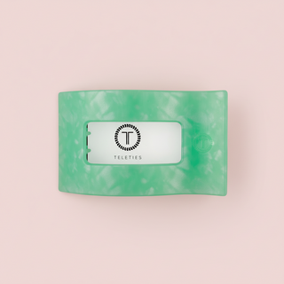 Green marbled hair clip on a pink background