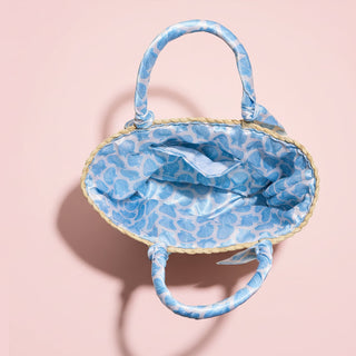 Blue patterned handbag on a pink background