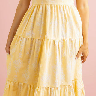 Yellow tiered dress on a pink background