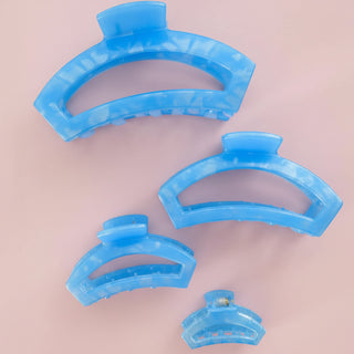 Set of blue hair clips on a pink background
