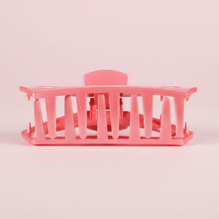 Pink hair clip with a label on a pink background
