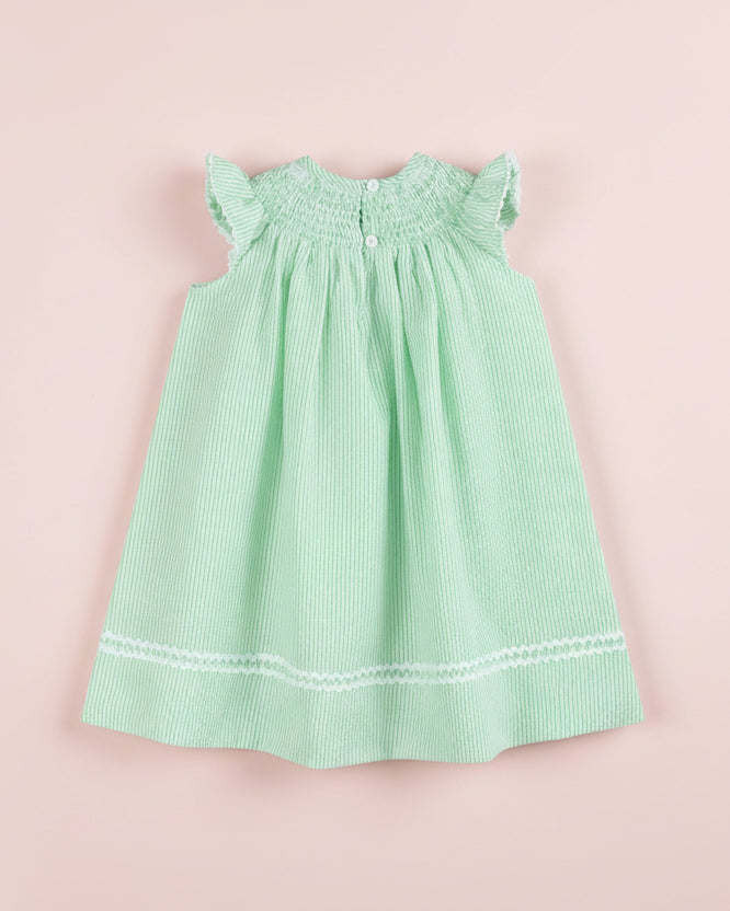 Green checkered dress with white trim on a pink background