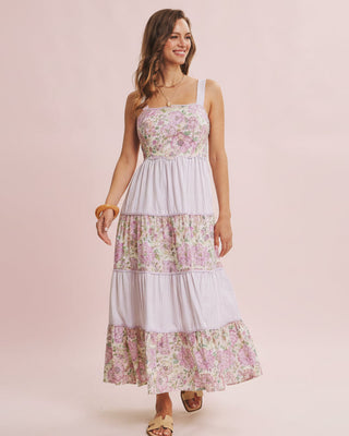 Woman wearing a floral tiered dress on a pink background