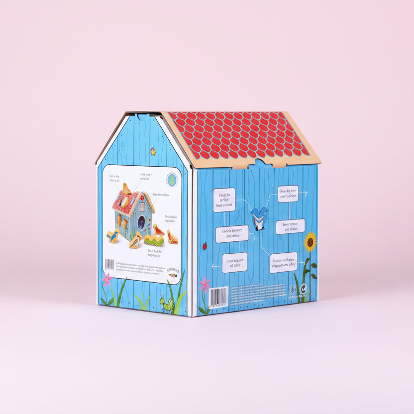 Children's toy birdhouse packaging with colorful design on a pink background