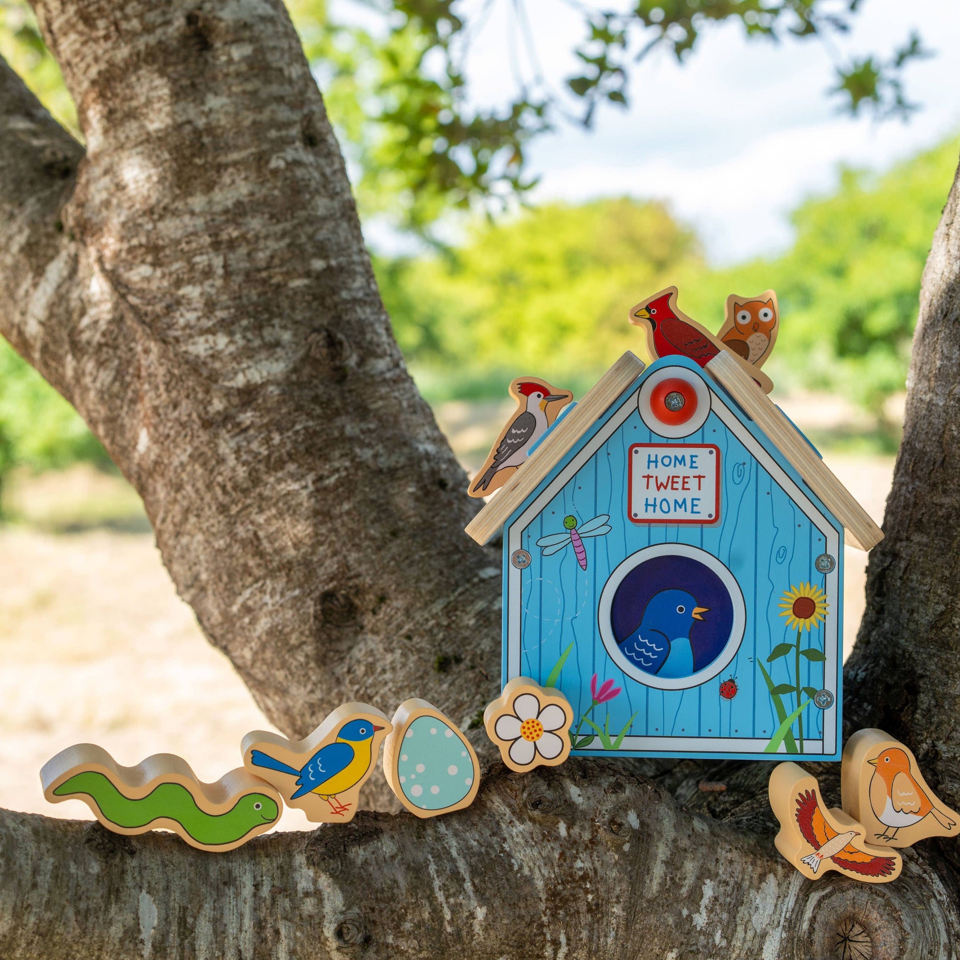 Decorative birdhouse and cookies on a tree branch with a natural background