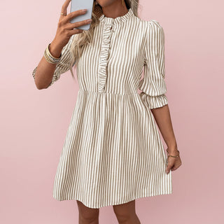 Woman wearing a striped dress against a pink background
