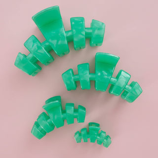 Green hair clip on a pink background