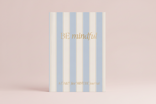 Striped notebook with 'BE mindful' text on a pink background