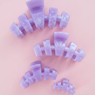 Purple hair clip on a pink background