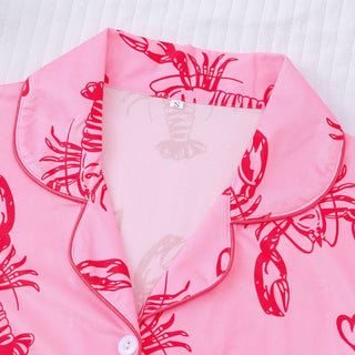 Pink shirt with red lobster pattern on a white background