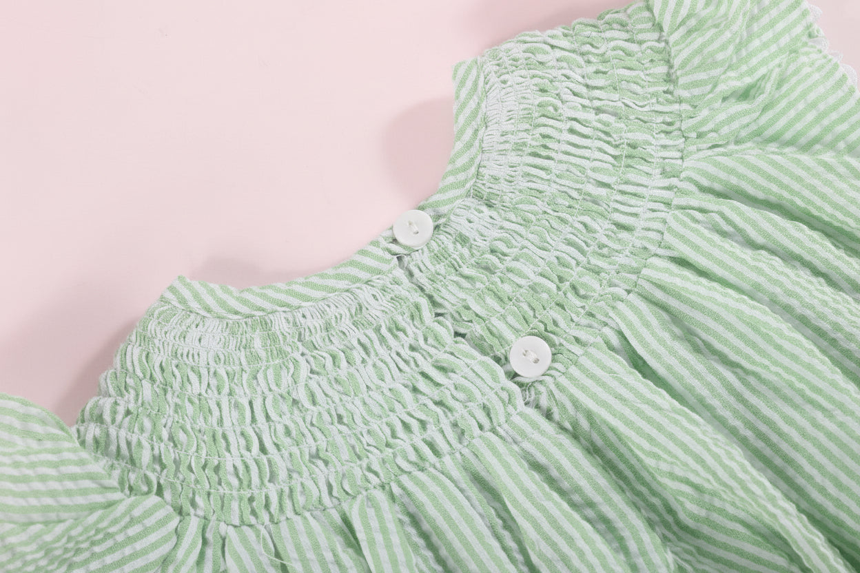 Close-up of a green textured fabric with a pink background