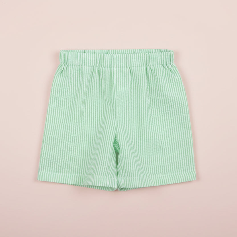 Green striped shorts on a pink background