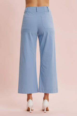 Light blue wide-leg pants worn by a person on a pink background