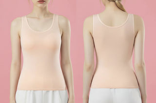 Woman wearing a beige tank top against a pink background