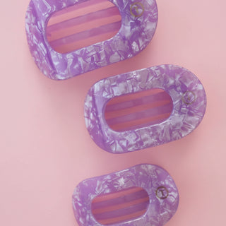 Purple marbled hair clip on a pink background