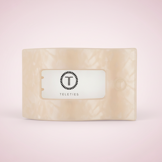 Beige soap bar with a label on a pink background