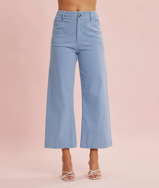 Light blue wide-leg jeans worn by a person on a pink background